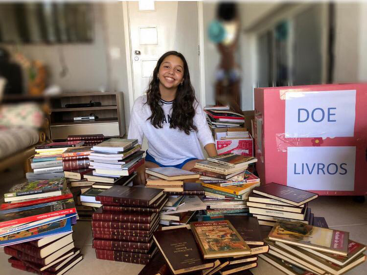 Voluntária com livros doados.